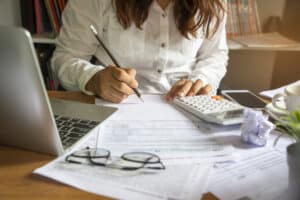 mulher empreendedora estudando o que é iss e fazendo os cálculos da sua empresa