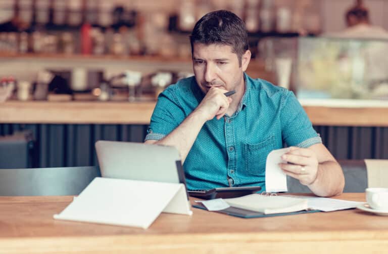 homem conferindo contas no tablet para calcular o simples nacional