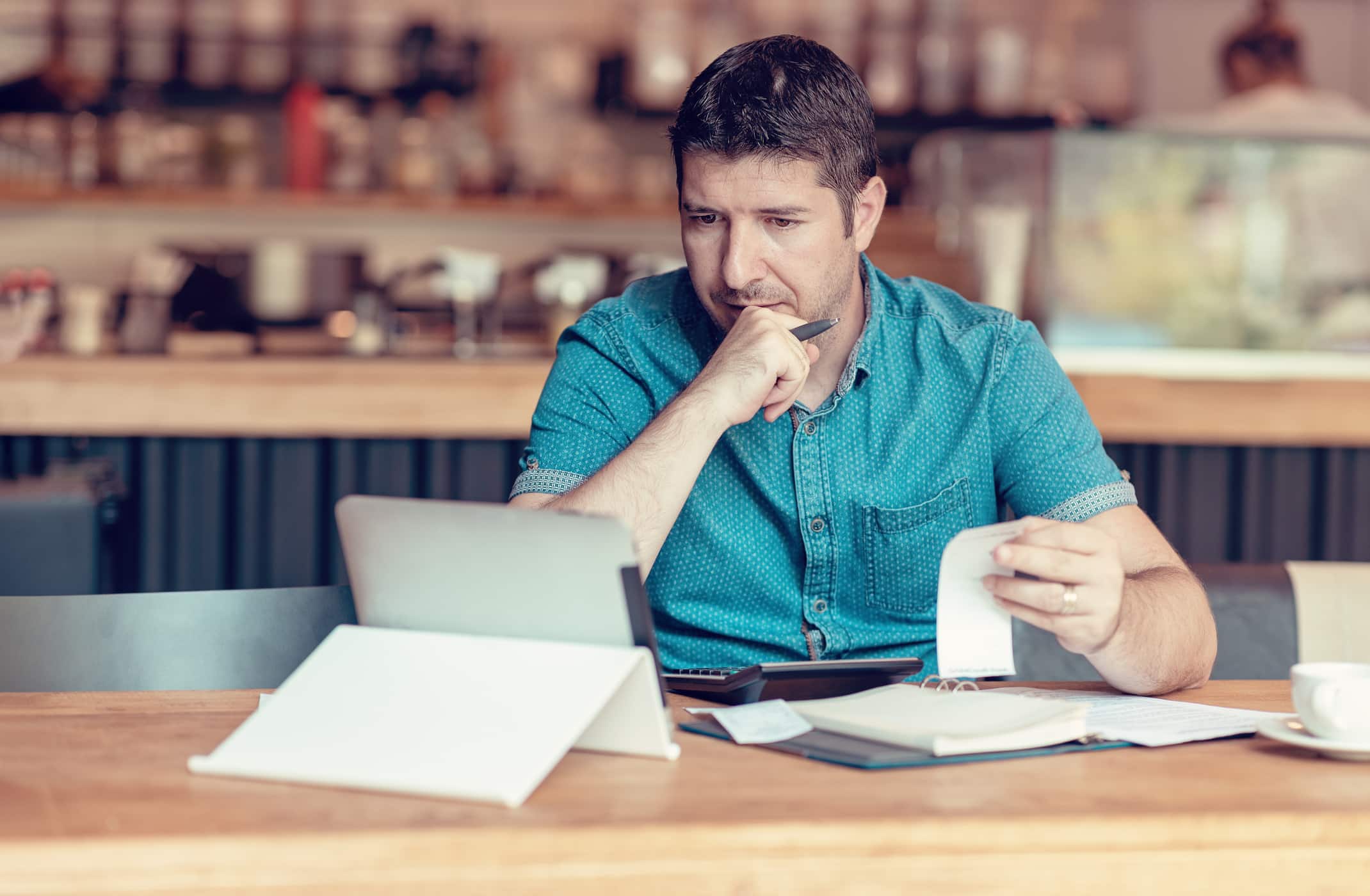 homem conferindo contas no tablet para calcular o simples nacional