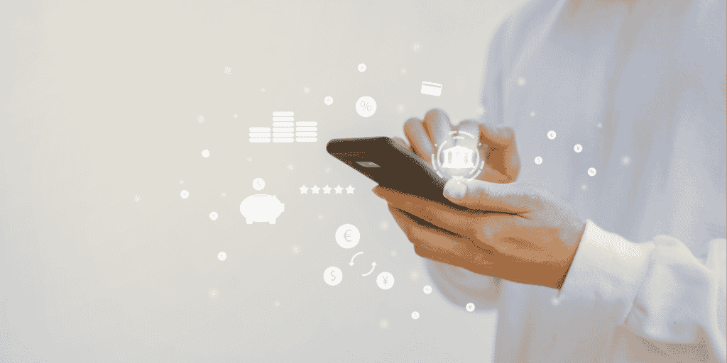 Pessoa em pé, segurando um celular com uma mão e mexendo na tela com a outra. Ao redor do aparelho estão ícones financeiros, como cifrão e um cofrinho.