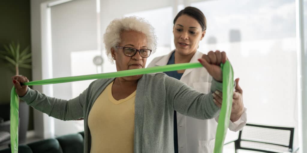 Profissional da área da saúde atende em seu local de trabalho após entender como montar uma clínica de fisioterapia.