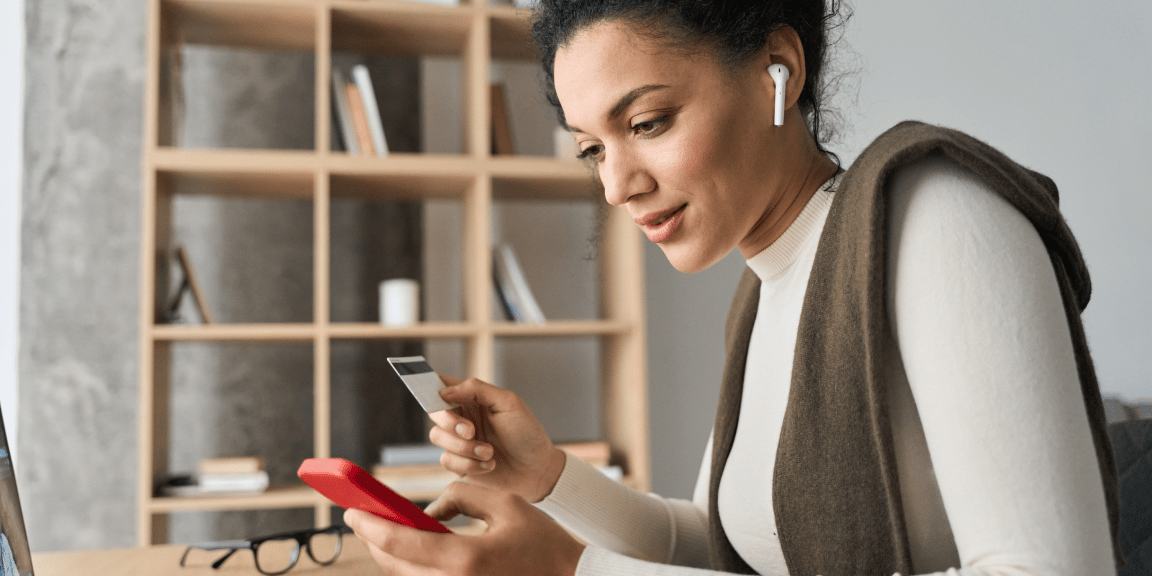 Empreendedora utilizando o aplicativo do banco após aprender como pedir cartão de crédito PJ.