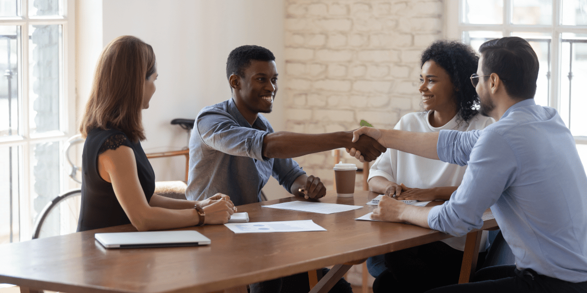Pessoas empreendedoras estão fechando uma parceria em seu escritório e discutindo os tipos de sociedade simples.