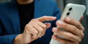 Imagem de uma pessoa utilizando seu smartphone ilustra artigo sobre clonagem de celular e WhatsApp