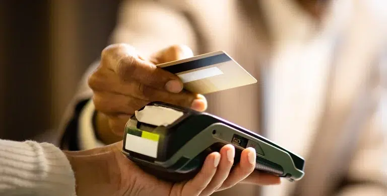 Uma pessoa efetua um pagamento com cartão de crédito em uma maquininha, em imagem que ilustra artigo sobre quais são os melhores cartões de crédito para pessoa jurídica