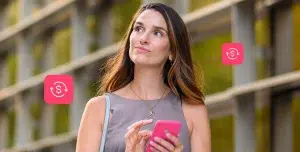 mãos de uma pessoa digitam em uma calculadora. Sobre uma mesa estão papeis e moedas, em imagem que ilustra artigo sobre crédito bancário para PJ