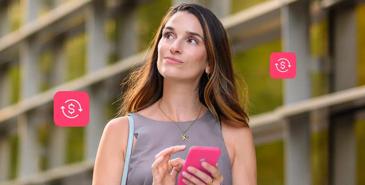 mãos de uma pessoa digitam em uma calculadora. Sobre uma mesa estão papeis e moedas, em imagem que ilustra artigo sobre crédito bancário para PJ