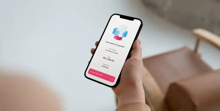Pessoa segura celular com o qual acabou de gerar um boleto bancário, em artigo sobre como gerar boletos gratuitos ou com menor taxa.