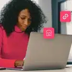 Mulher trabalhando em seu computador. Na fotomontagem, que ilustra artigo sobre como vincular empresas via e-CNPJ, há também ícones digitais.