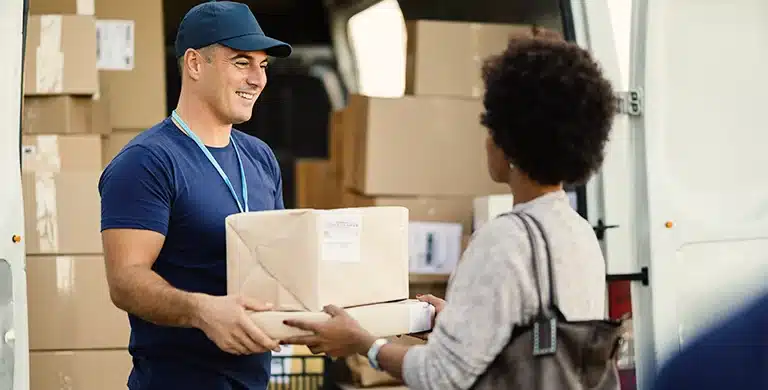 Homem faz entrega de caixas para mulher, em imagem que ilustra artigo sobre gestão de fornecedores.