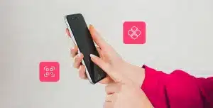 Fotomontagem das mãos de uma pessoa mexendo no smartphone, com ícone de Pix ao redor, para ilustrar artigo sobre tipos de Pix.