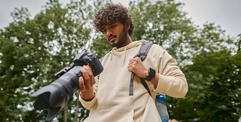 Fotógrafo observa o display de sua câmera fotográfica, em imagem que ilustra artigo sobre trabalho freelancer