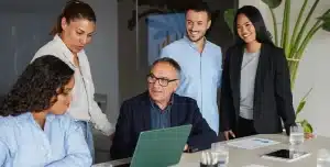 Pessoas conversam em uma sala de reunião, em imagem que ilustra artigo sobre empréstimo para pagar férias coletivas