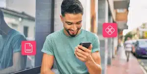 Homem sorri ao olhar a tela de seu smatphone. A fotomontagem também tem ícones financeiros e ilustra artigo sobre Pix Automático e débito automático.