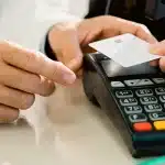 Pessoa efetua pagamento com cartão em uma maquininha, em imagem que ilustra artigo sobre o que deve constar na política de cartão corporativo para equipes pequenas.