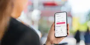 Pessoa segurando um smartphone com o aplicativo da Cora aberto, exibindo dados financeiros na tela, em imagem que ilustra artigo sobre conta PJ da Cora é boa para empresas em crescimento.