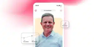 Pessoa sorridente em destaque na tela de um smartphone com o aplicativo da Cora aberto, ícone de transferência visível e gráfico simples com valores financeiros, em imagem que ilustra um case de sucesso da conta PJ da Cora para escritório de contabilidade.