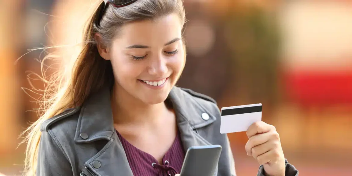 moça sorridente com o seu cartao de credito sem anuidade