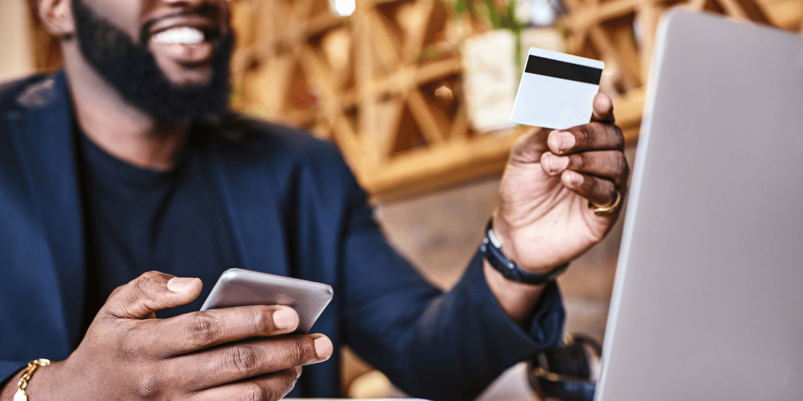 Empreendedor com celular e cartão de crédito em mãos após abrir uma conta online pj.